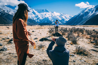 Rear view of woman standing on snowcapped mountain