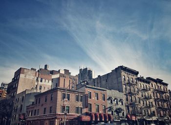 Buildings in city against cloudy sky