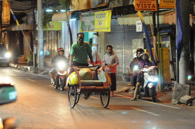 People riding motorcycle on street at night