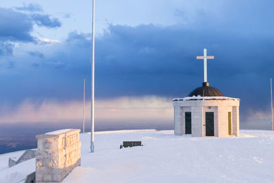 Built structure on snow covered building against sky