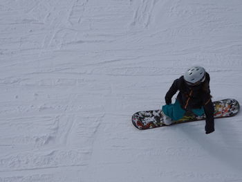 High angle view of person snowboarding on field