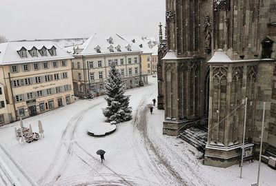 Man on snow covered road in city