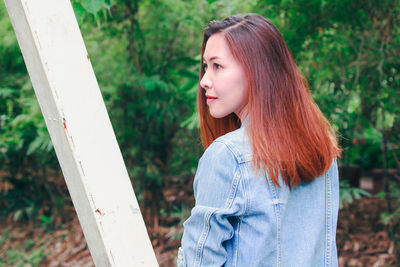 Side view of young woman standing outdoors