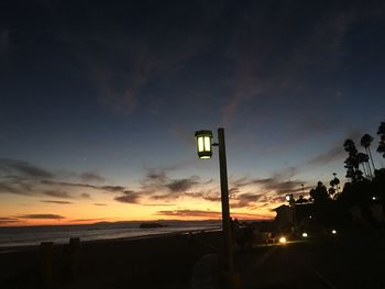 Illuminated road against sky at night