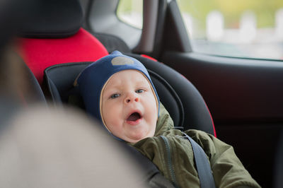 Portrait of cute baby boy yawning in car