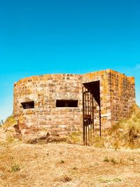 Old abandoned building against clear blue sky