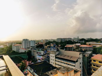 High angle view of city buildings against cloudy sky