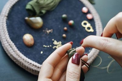 Close-up of woman holding hands on pebbles