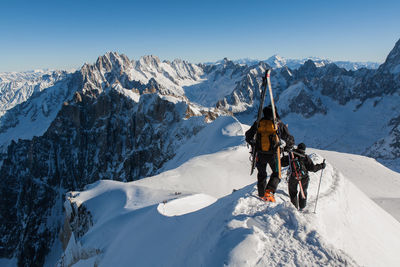 Tourists walking on snow covered landscape