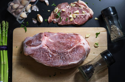 High angle view of meat on cutting board over table