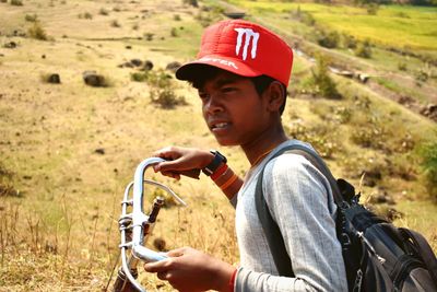 Side view of boy holding bicycle