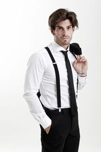 Portrait of young man standing against white background