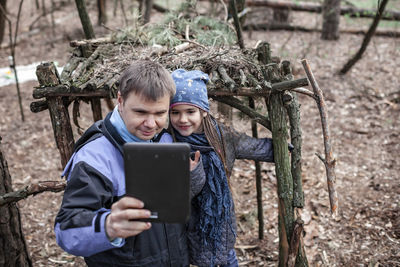 Father and daughter doing selfie while standing outdoors