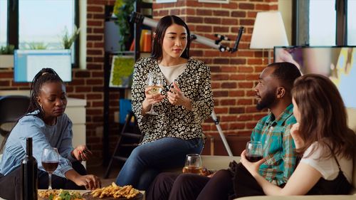 Portrait of smiling friends using digital tablet while sitting on table