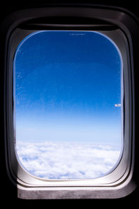 View of cloudy sky seen through airplane window