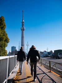 Rear view of man and woman standing on street in city