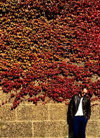 Man standing by ivies on wall