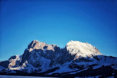 Snowcapped mountains against clear blue sky