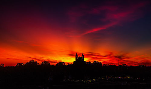 Silhouette buildings against sky during sunset