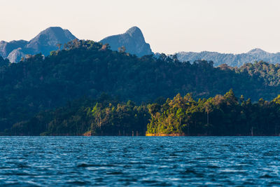 Scenic view of sea and mountains against clear sky