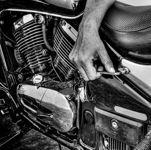 Cropped hand of man repairing motorcycle