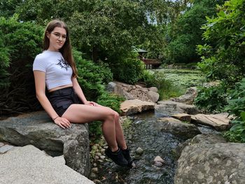 Portrait of young woman sitting on rock