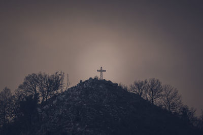 Low angle view of cross on building against sky