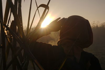 Silhouette man standing against sky during sunset