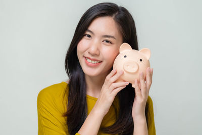 Portrait of a smiling young woman against white background