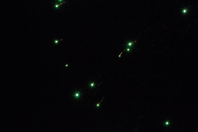 Low angle view of illuminated lights against sky at night