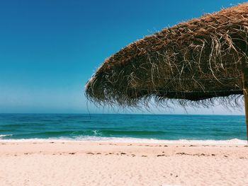 Scenic view of beach against clear blue sky