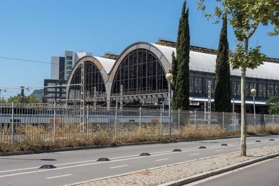 Road by buildings against clear sky