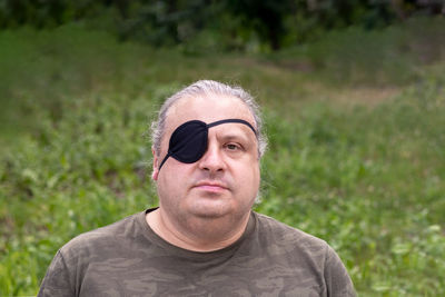 Portrait of young man wearing sunglasses while standing against plants