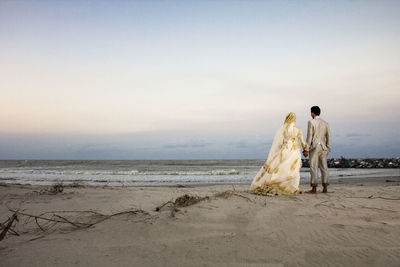 Couple at beach against sky