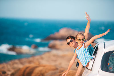 Woman wearing sunglasses on beach against sky