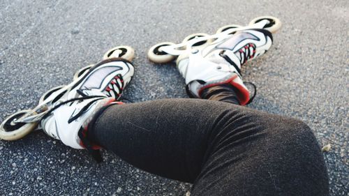 Low section of person wearing inline skates on road