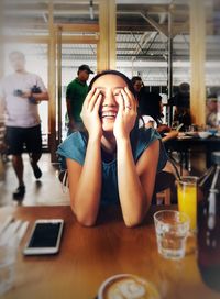 Portrait of young woman sitting in restaurant