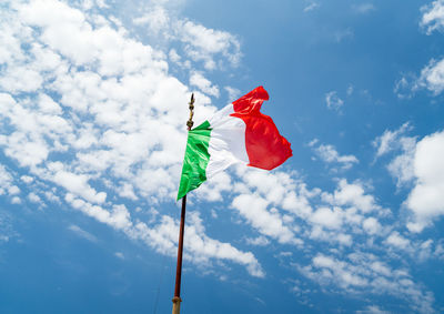 Low angle view of red flag against blue sky