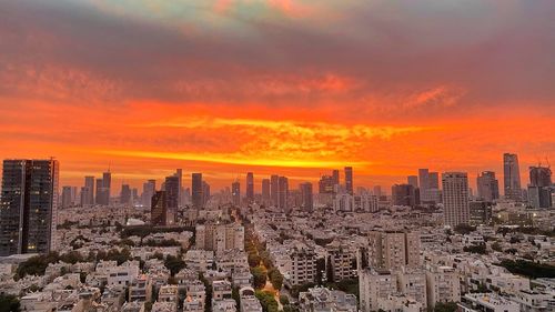 Aerial view of buildings in city during sunset