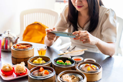 Midsection of woman having food at table