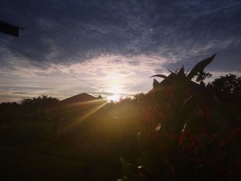 Scenic view of silhouette field against sky at sunset