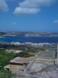 Aerial view of town by sea against sky