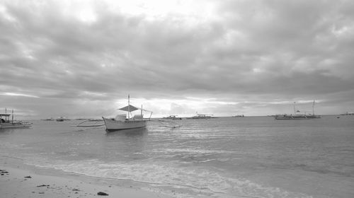 Boats sailing on sea against sky