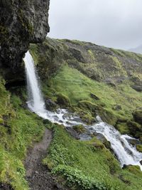 Scenic view of waterfall against sky