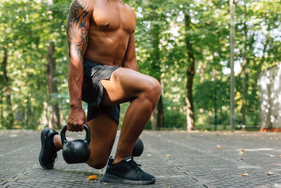 Full length of shirtless man lying in park