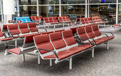 Empty chairs and table against window