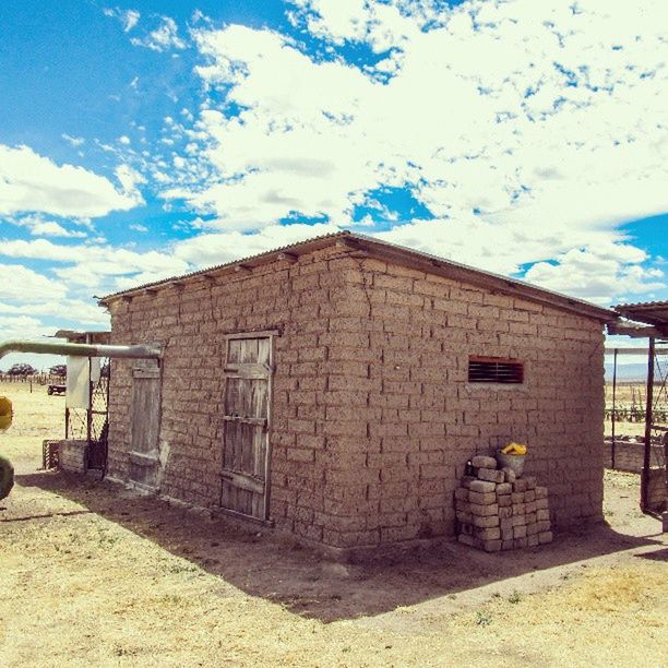 building exterior, architecture, built structure, sky, sunlight, wall - building feature, cloud - sky, abandoned, day, house, outdoors, blue, street, cloud, shadow, old, graffiti, building