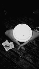 High angle view of hand holding tea cup on table