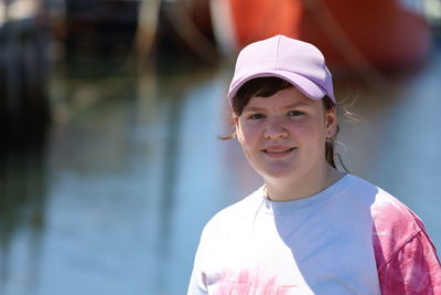 Portrait of a smiling girl with fishing boats blurred in background