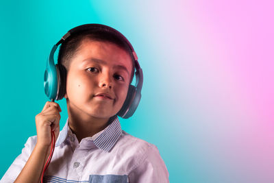 Close-up portrait of a boy against blue background